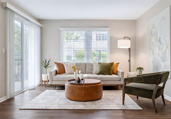 A living room with a white couch, a brown coffee table, and a green armchair.