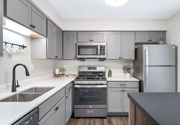A modern kitchen with a stainless steel refrigerator, oven, and microwave.