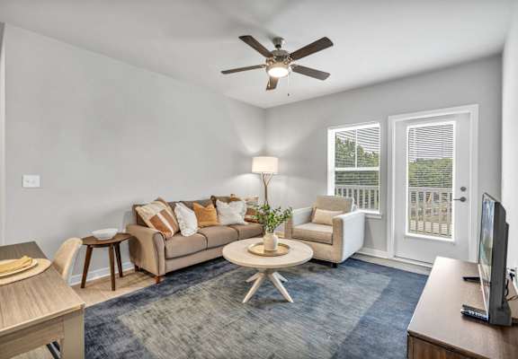 a living room with a couch and a ceiling fan