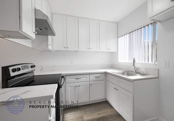 a white kitchen with white cabinets and a sink