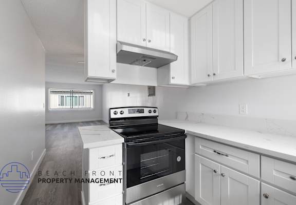 a white kitchen with white cabinets and a black stove and