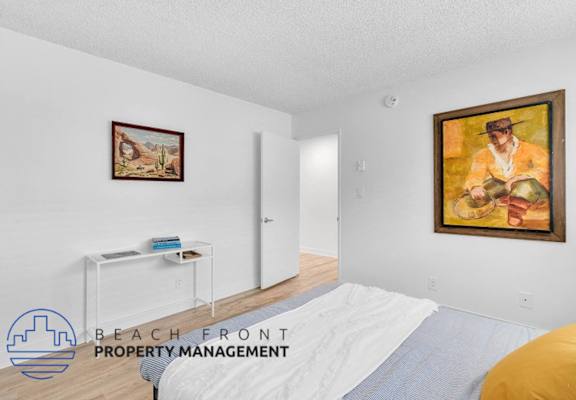 a bedroom with a bed and a painting on the wall