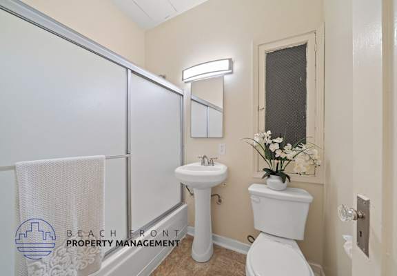 A white toilet sits next to a sink in a small bathroom.