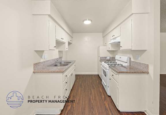 A kitchen with white appliances and wooden floors.