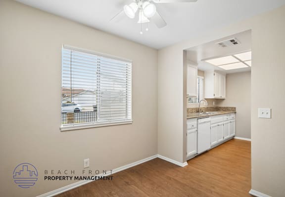 A room with a window showing a view of a beach and a logo for Beach Front Property Management.