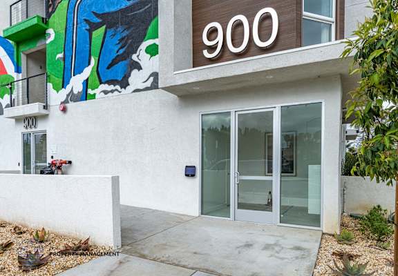 A building with a mural on the wall and a number 900 on the top.