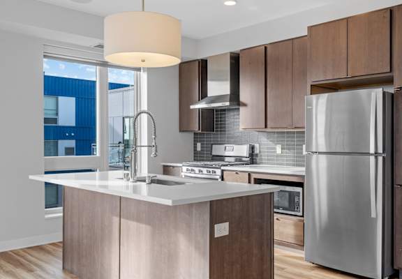 A modern kitchen with a large island and stainless steel appliances.