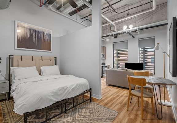 A bedroom with a bed, desk, and chair.