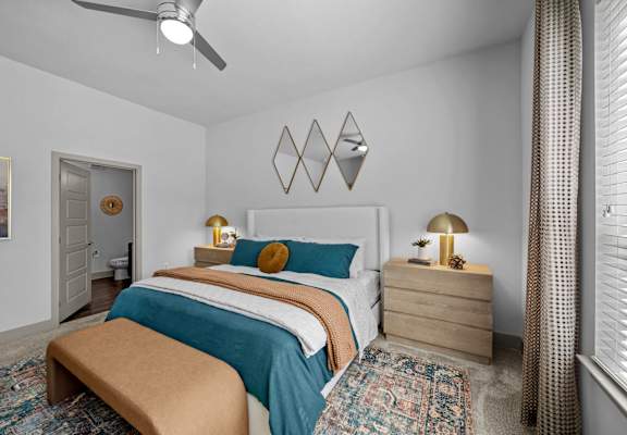 A bedroom with a bed, nightstand, and a rug.