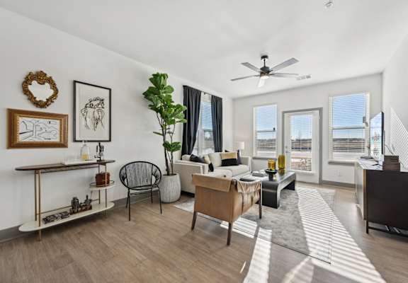 A living room with a couch, chair, and a plant.