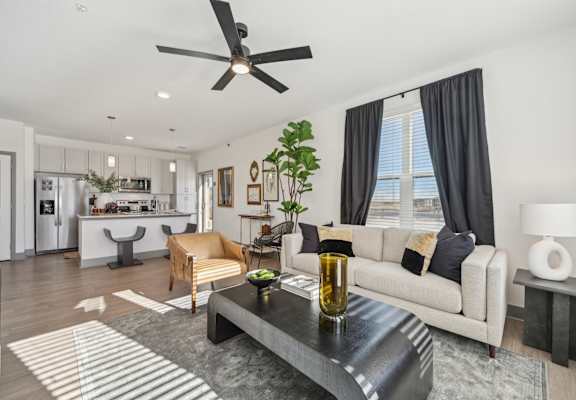 A modern living room with a black coffee table and a white sofa.