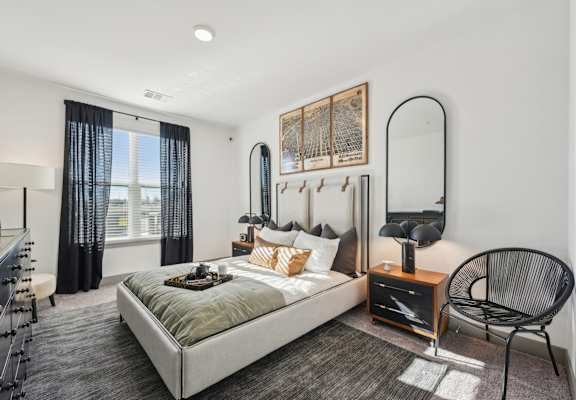 A bedroom with a large bed and a chair.