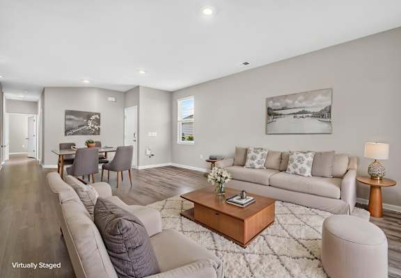 A living room with a grey couch, a coffee table, and a painting on the wall.