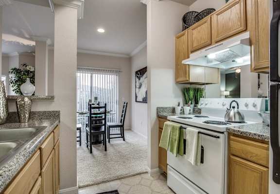 an open kitchen and dining room with white appliances and wood cabinets