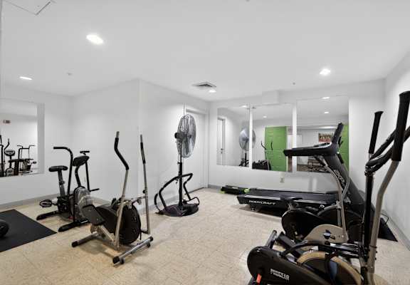 A room with a treadmill, elliptical trainer and other exercise equipment.