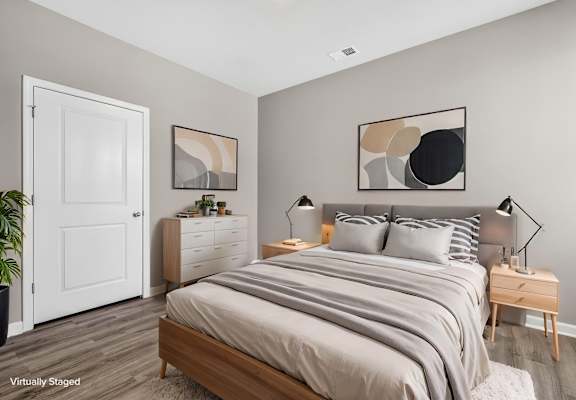 A bedroom with a large bed and a white door.