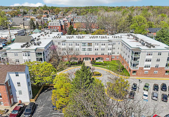 A large apartment complex with a parking lot in front.