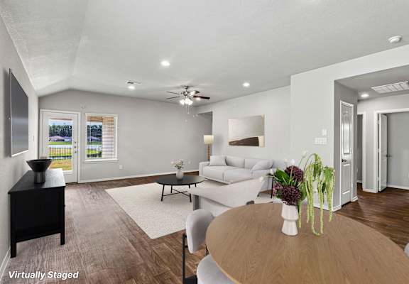 A living room with a couch, a coffee table, and a ceiling fan.