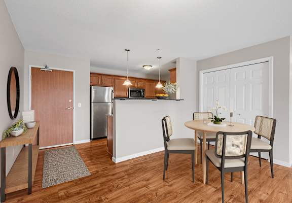 a dining room and kitchen with a table and chairs and a refrigerator