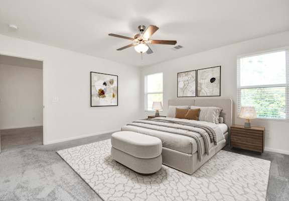 A bedroom with a large bed and a ceiling fan.