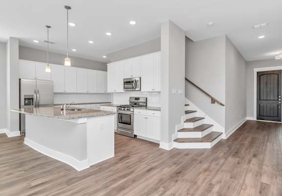 a kitchen with white cabinetry and a kitchen island with a granite countertop