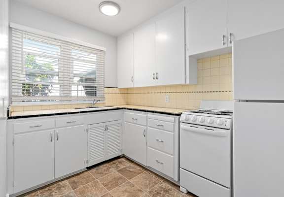 a kitchen with white cabinets and white appliances