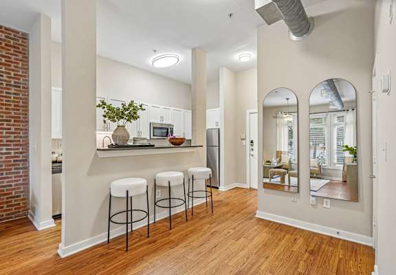 A kitchen with a bar and stools.