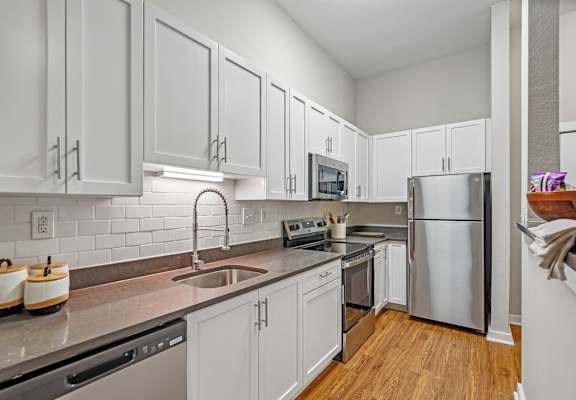A kitchen with white cabinets and stainless steel appliances.
