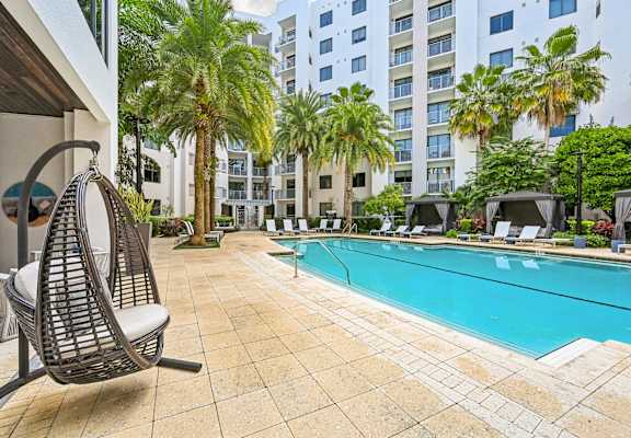 A chair is on a patio next to a pool.