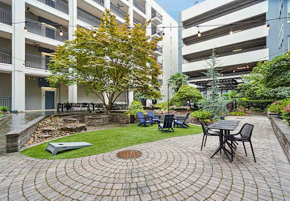 A courtyard with a table and chairs surrounded by buildings.
