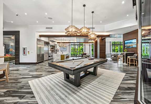 A billiard table is in the middle of a room with a striped rug.