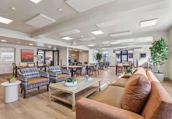 A spacious waiting room with brown couches and a coffee table. at The Orion Senior Apartments - Orange, CA Apartments, California, 92866