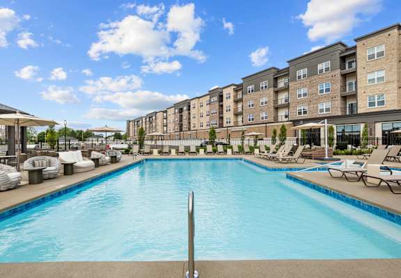A large swimming pool in front of apartment buildings.