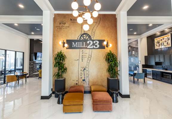 the lobby of mill 23 with couches and a wall with a sign on it