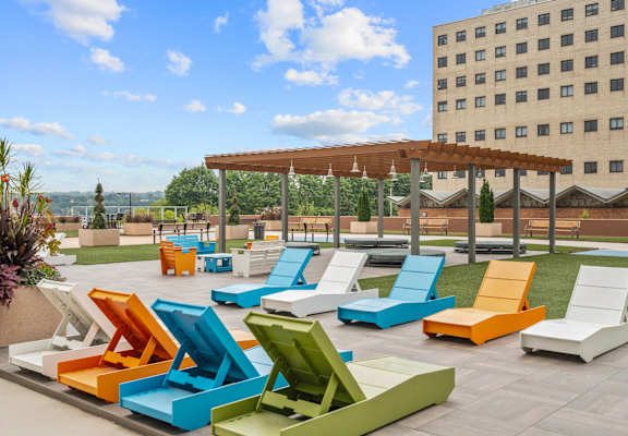 A collection of brightly colored chairs are arranged on a patio.