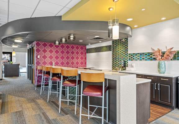 A modern kitchen with a bar area and stools.