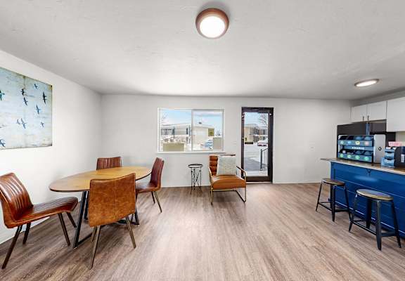 a dining room with a table and chairs and a kitchen with a blue counter