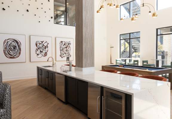 A kitchen with a white counter top and a black and white fridge.