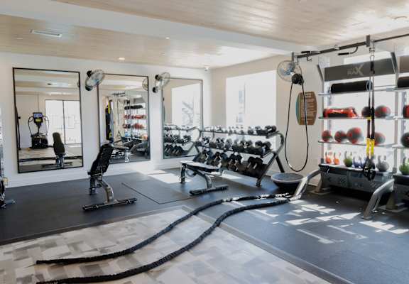 A gym with a variety of equipment including a rowing machine.