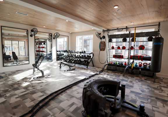 A gym with a variety of equipment including a treadmill, weights, and a punching bag. at The Wren Apartments, Lawrenceville, 30043