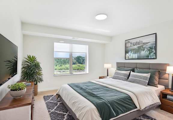 A bedroom with a large bed and a flat screen TV.