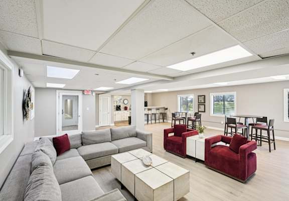 A living room with a grey couch and a red chair.