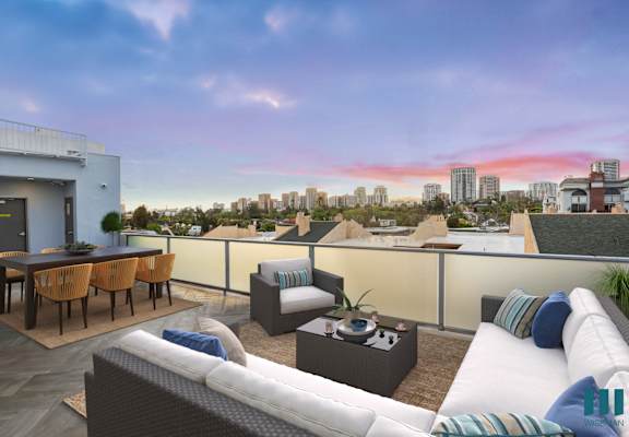 A rooftop patio with a table and chairs.