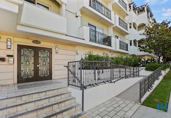 an apartment building with stairs and a brown and white door