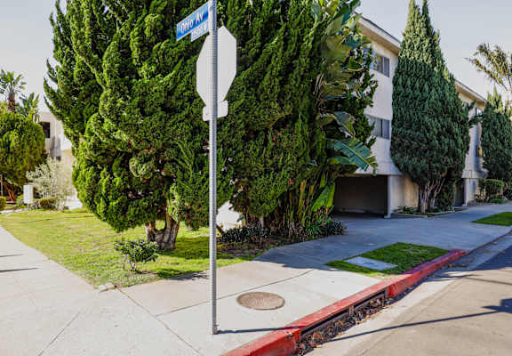 A street sign on a pole in front of a house.