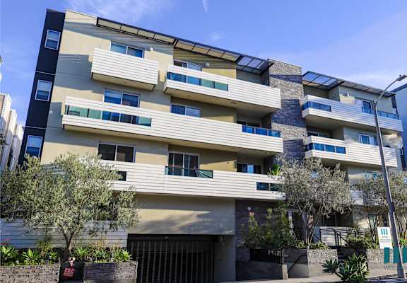 the exterior of a building with balconies and a garage