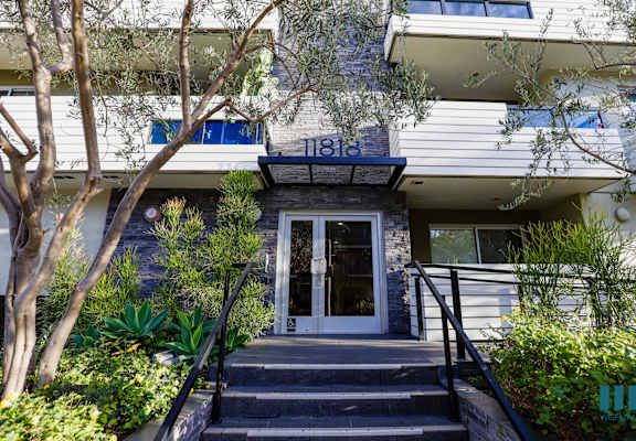 the front of a building with stairs and a door