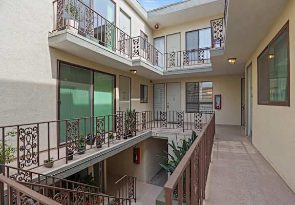 A balcony with a railing and potted plants.