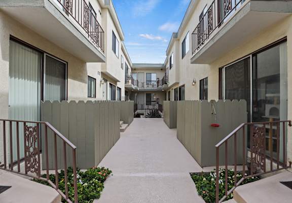 A long hallway with a metal railing and a gate at the end.