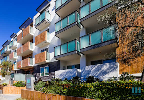 a row of apartments with balconies and a sidewalk